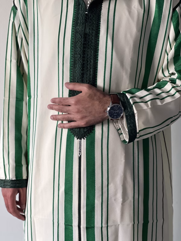 Close-up embroidery detail on striped green and white Moroccan thobe